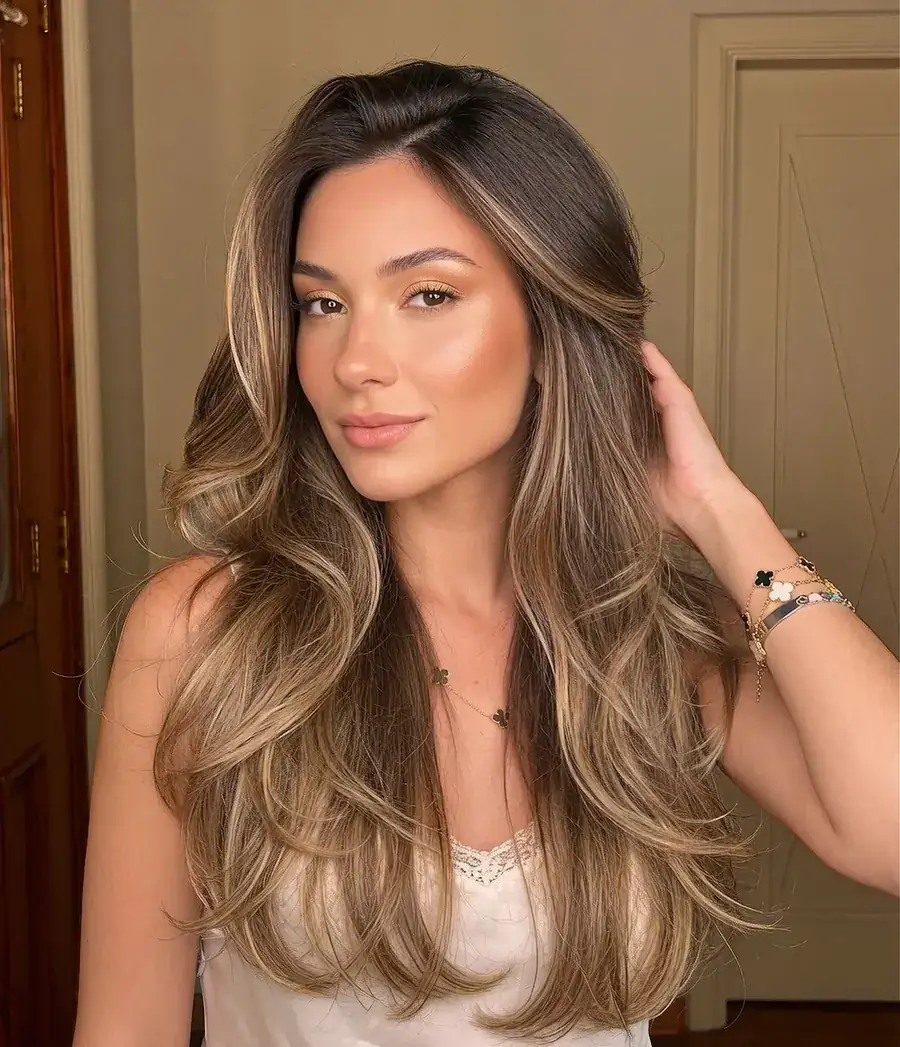 Cliente com mechas suaves e raiz escura, cabelo longo